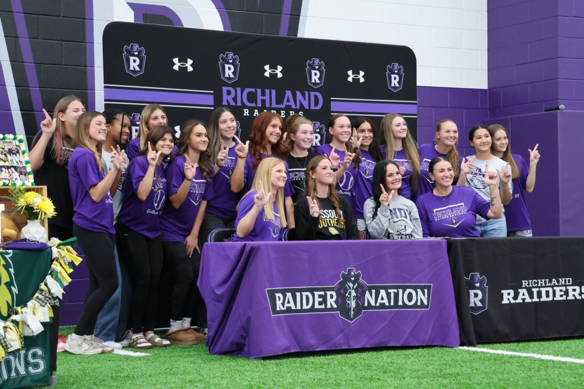 Grouped together, the team smiles for a photo. The sign off is for softball. The Richland Softball team will have their first game on January 24, 2026.