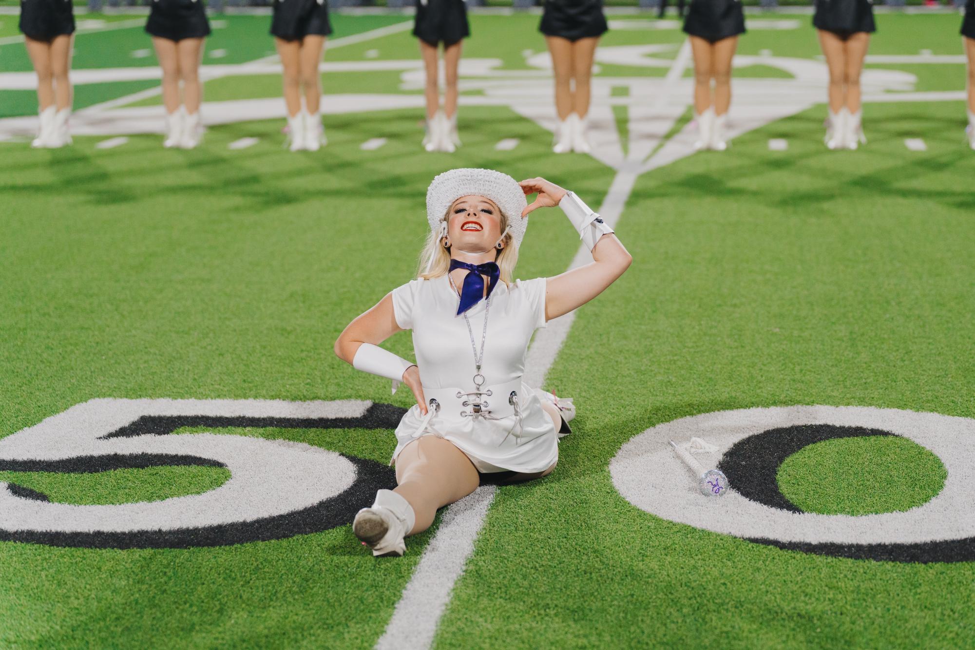 Doing the splits on the field, senior Kadielyn Kopil smiles at the camera. This was taken during a football game halftime show. "I love being captain and serving my team," Kopil said. "I just want to serve people and I feel like I really get to do that being captain."